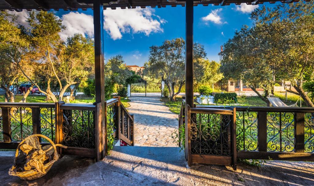 ein offenes Tor in einem Park mit Bäumen im Hintergrund in der Unterkunft Villa Joy in Ormos Panagias