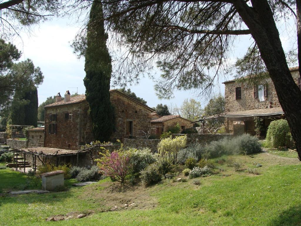 stary kamienny dom z drzewem na podwórku w obiekcie Nocini di Maremma w mieście Tatti