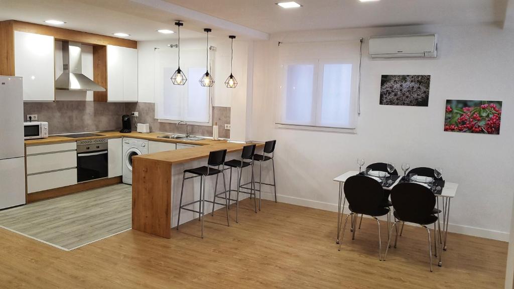 a kitchen with a counter and stools in it at Loft Yolanda Centro in Cuenca