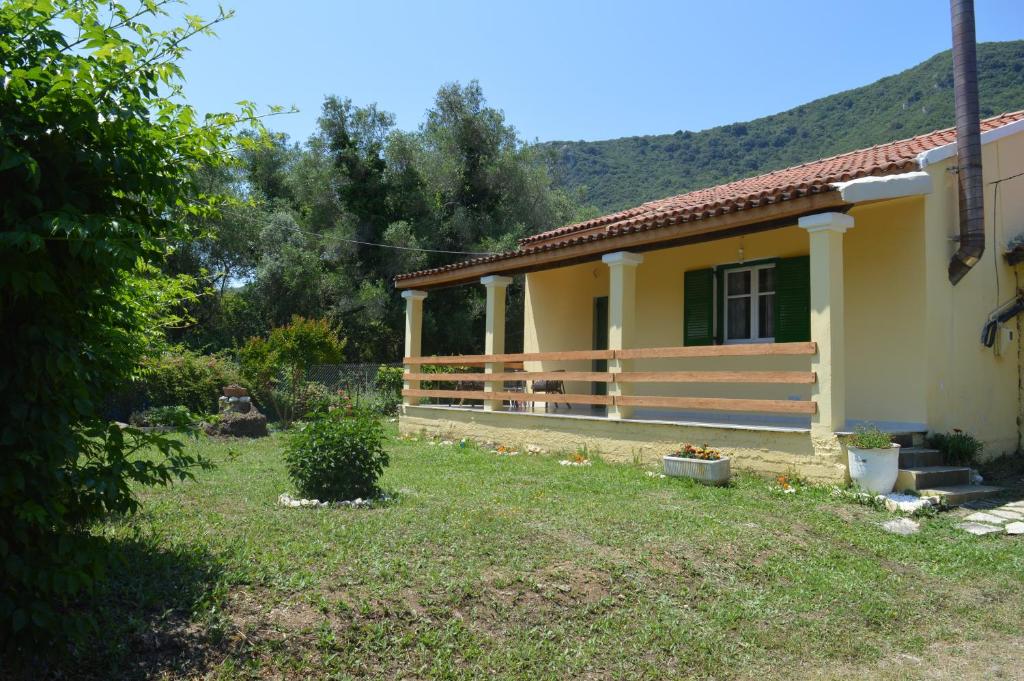 una pequeña casa amarilla con patio en Kathrin's House, en Vátos