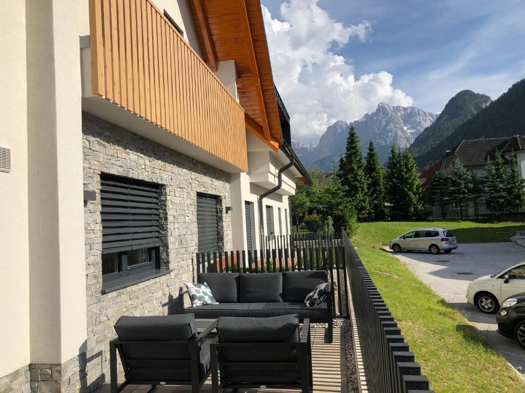a patio with a couch and chairs on the side of a building at VILA Mojca - APARTMENT PERIDOT - Center in Kranjska Gora