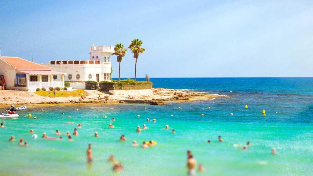 een groep mensen in het water op een strand bij CostaAzul loft, Seaviews frente al mar, Playa los locos in Torrevieja