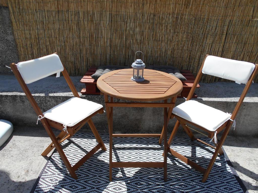 a wooden table with two chairs and a lamp on it at Apartmani Ino in Škrip