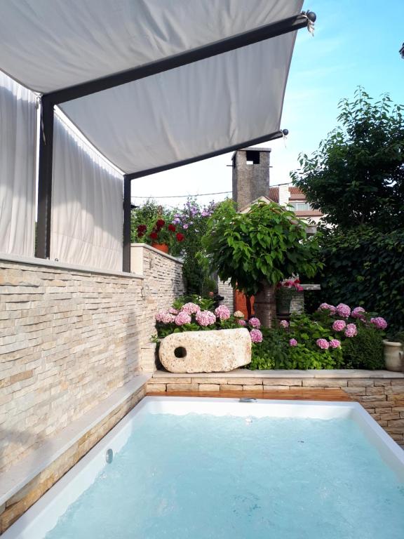 a swimming pool in a backyard with a canopy at Apartments Vuković in Podstrana