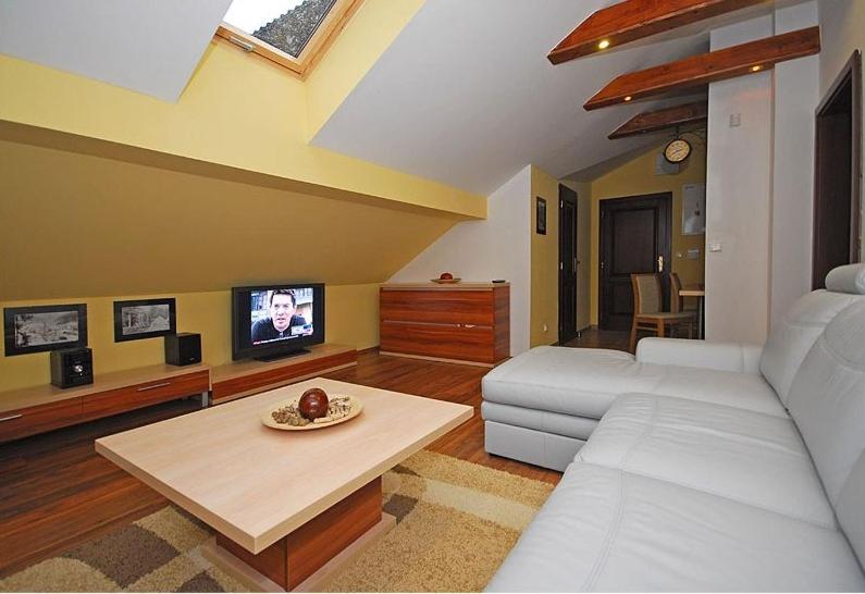 - un salon avec un canapé blanc et une télévision dans l'établissement Apartmán pri jazere, à Ružomberok