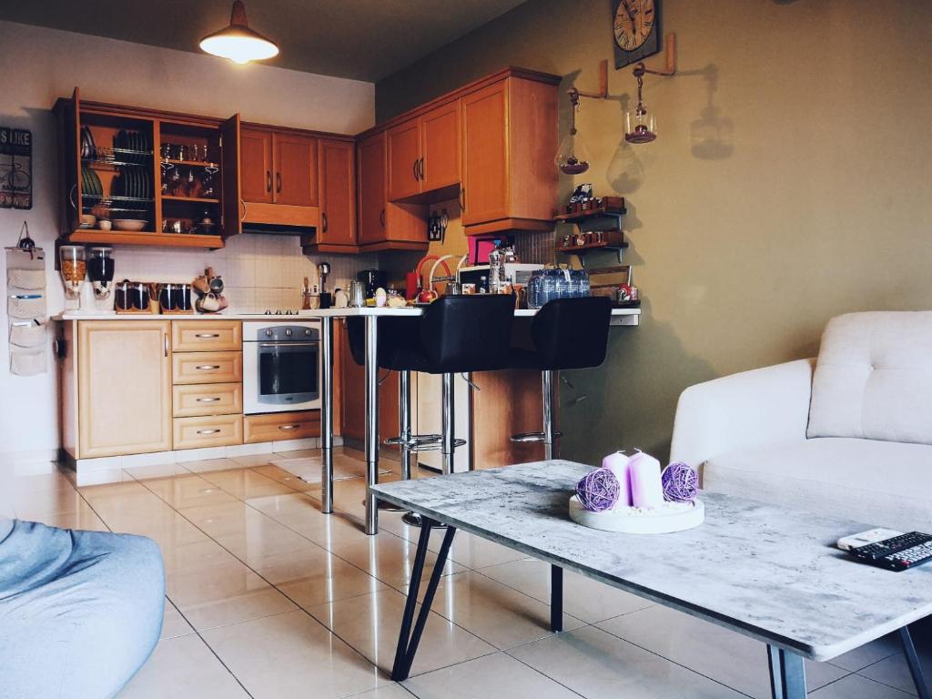 a living room with a table and a kitchen at Ria Court 33 in Larnaca