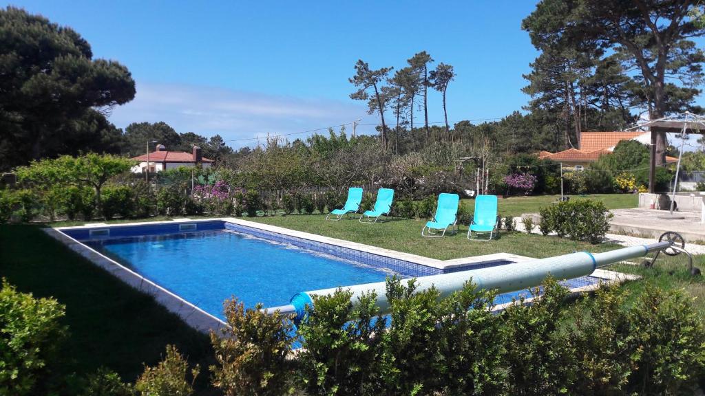 a swimming pool with two lawn chairs and a swimming pool at Sintra Vintage Tent in Sintra