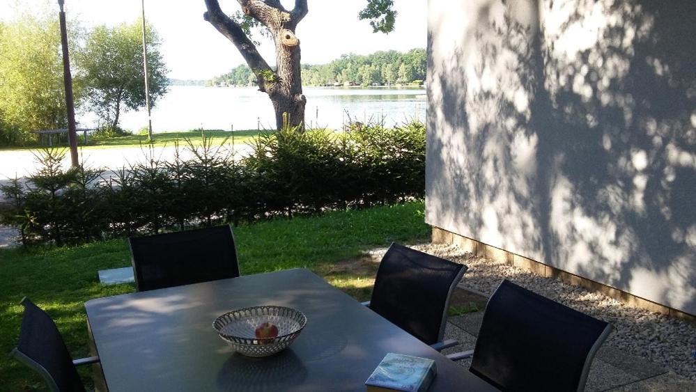 伏爾塔瓦河畔赫盧博卡的住宿－Chata Bezdrev u Hluboké nad Vltavou，桌椅,享有湖景