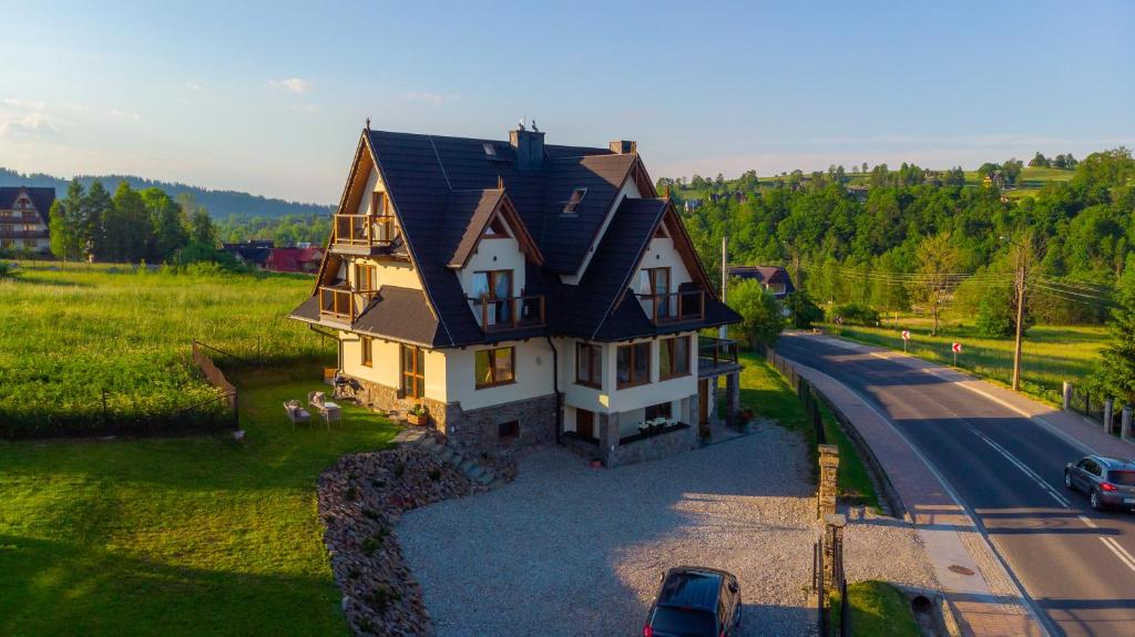 a large house with a black roof on a road at Willa Rychlina in Zakopane