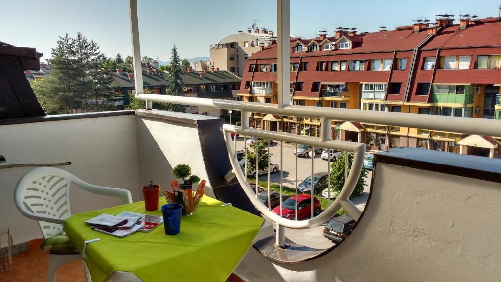 a green table and chairs on a balcony at Cozy Dream Apartment in Sarajevo