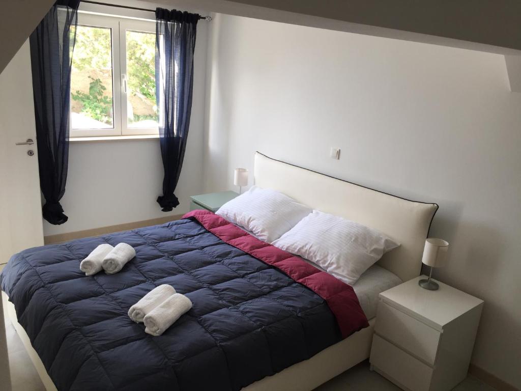 een slaapkamer met een bed met twee handdoeken erop bij Fig Tree in Povlja