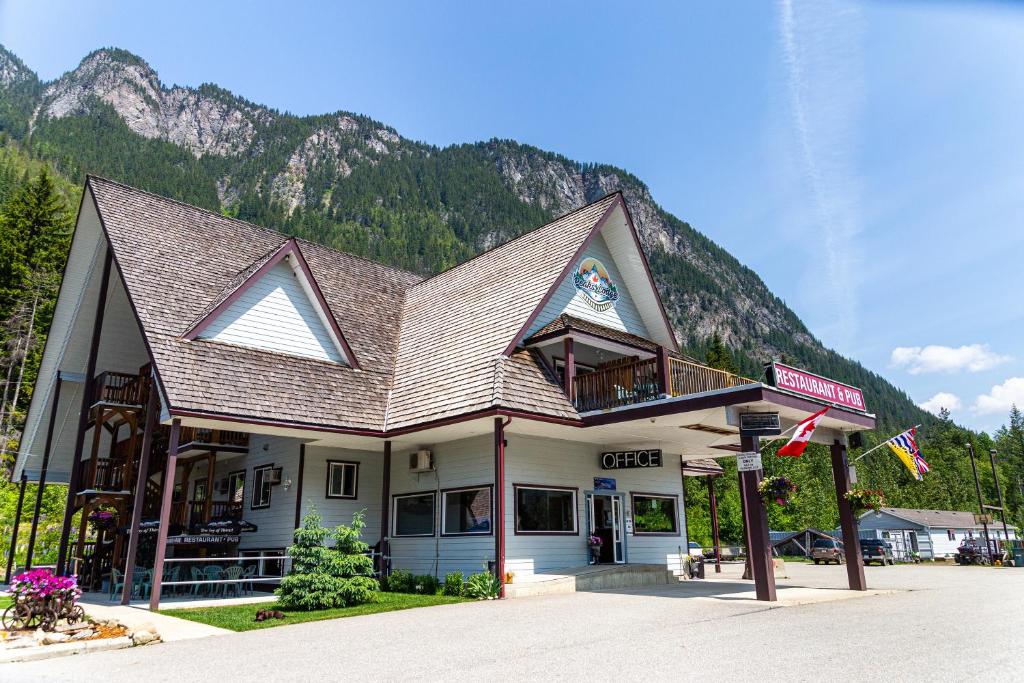 a building with a roof with a mountain in the background at Peaks Lodge in Revelstoke
