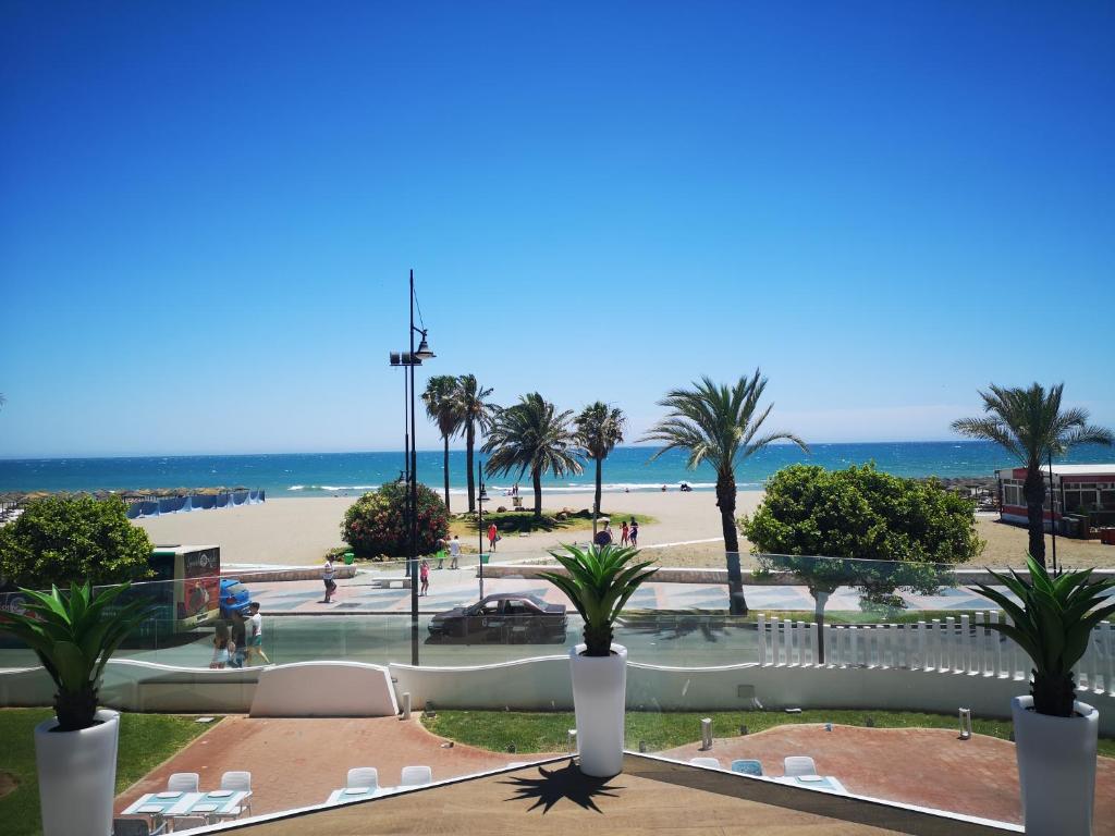 widok na plażę z palmami i ocean w obiekcie Cozy Loft Near The Beach w mieście Torremolinos