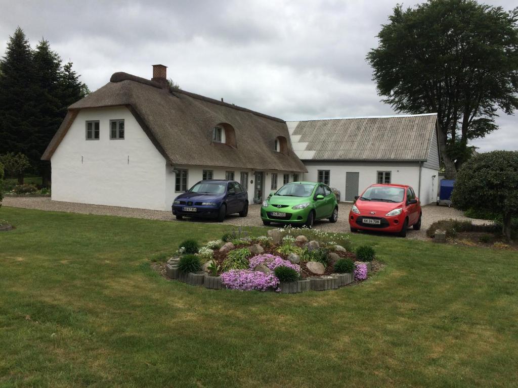 drei Autos auf einem Hof neben einem Haus geparkt in der Unterkunft Dalsgaard in Vojens