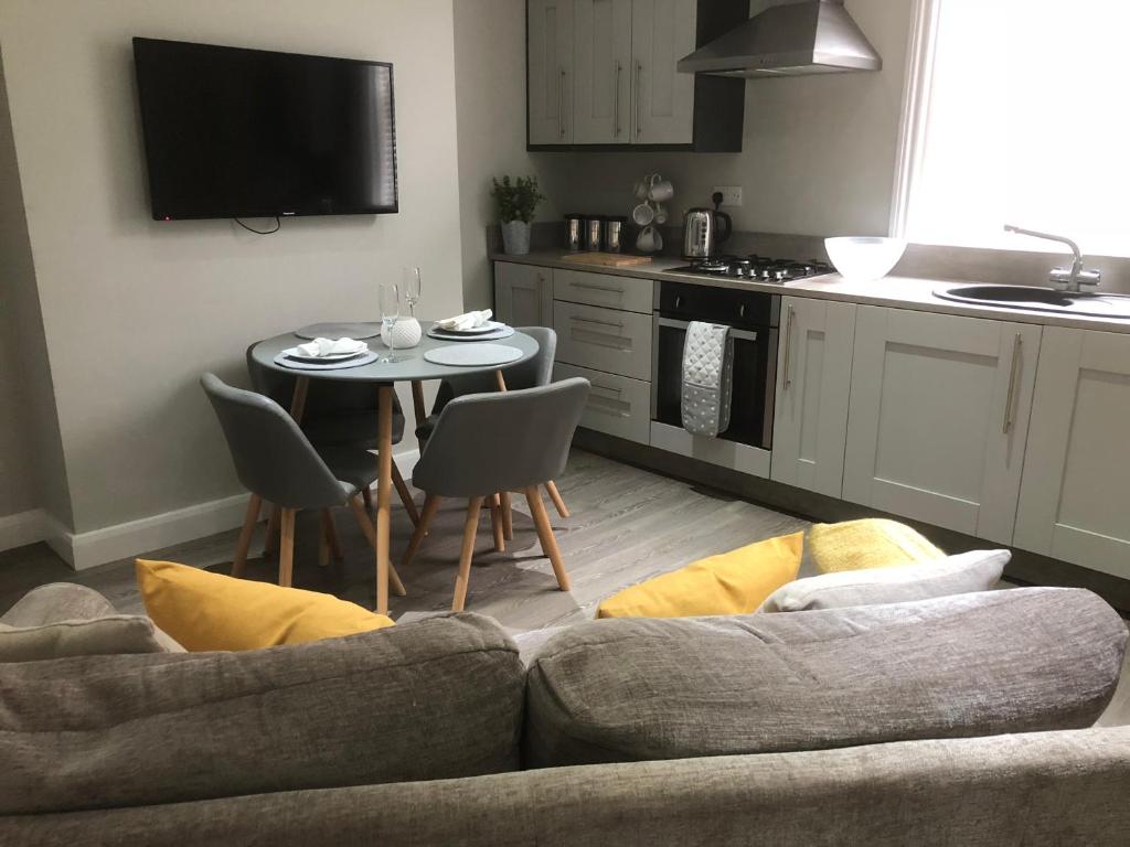 a living room with a couch and a table with chairs at Stanley Street Apartment in Southport
