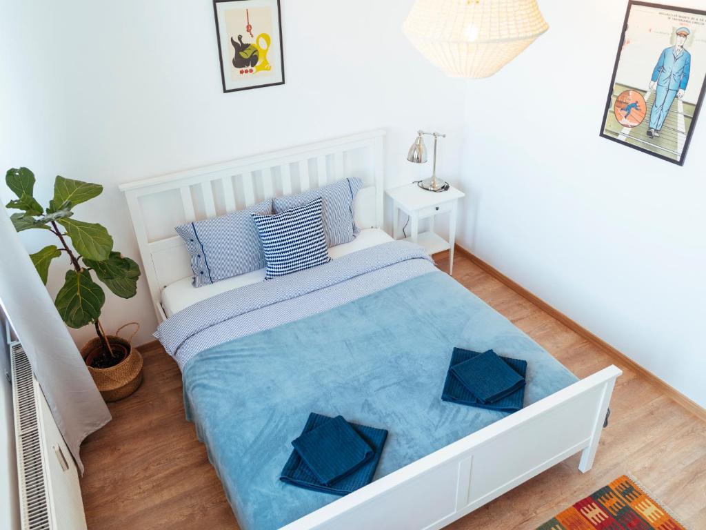 een witte slaapkamer met een bed met blauwe lakens bij Parkview Apartment - Spectacular View & 2 bedrooms in Boekarest