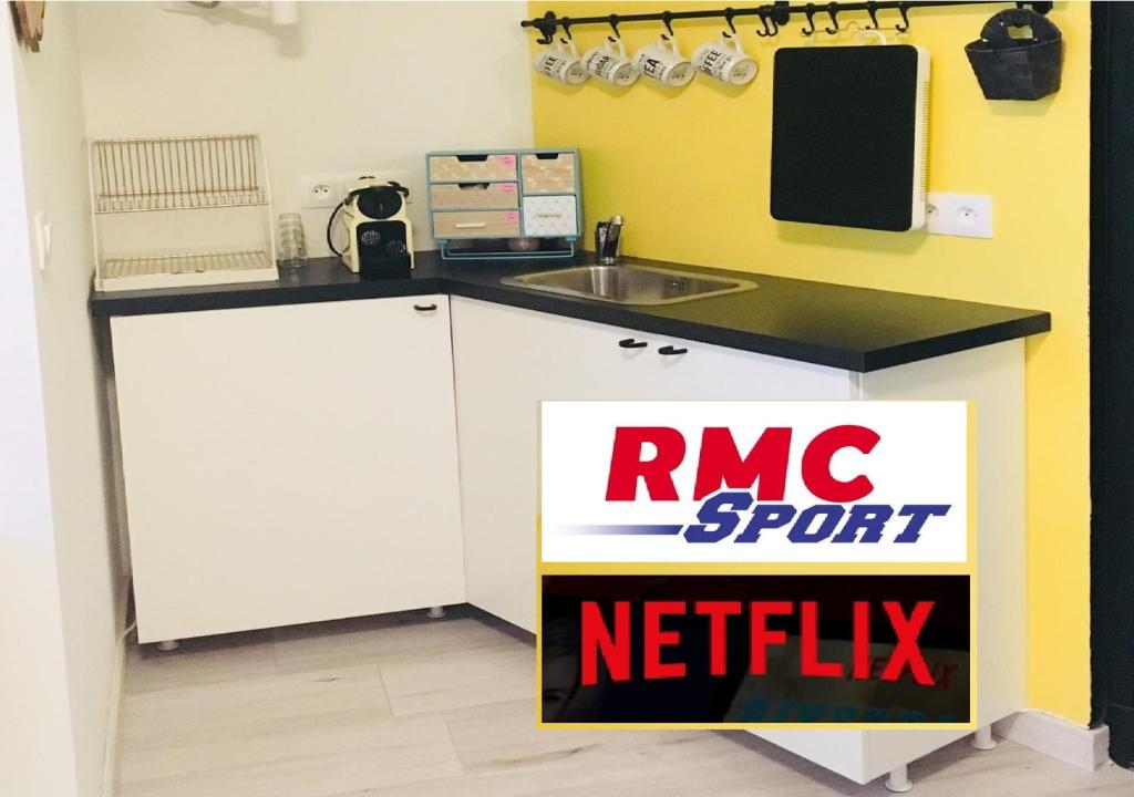 eine Küche mit einem rnc Sport-Netflix-Schild auf der Theke in der Unterkunft ★★ Studio Coeur Toulouse, Saint Georges, Capitole ★★ in Toulouse
