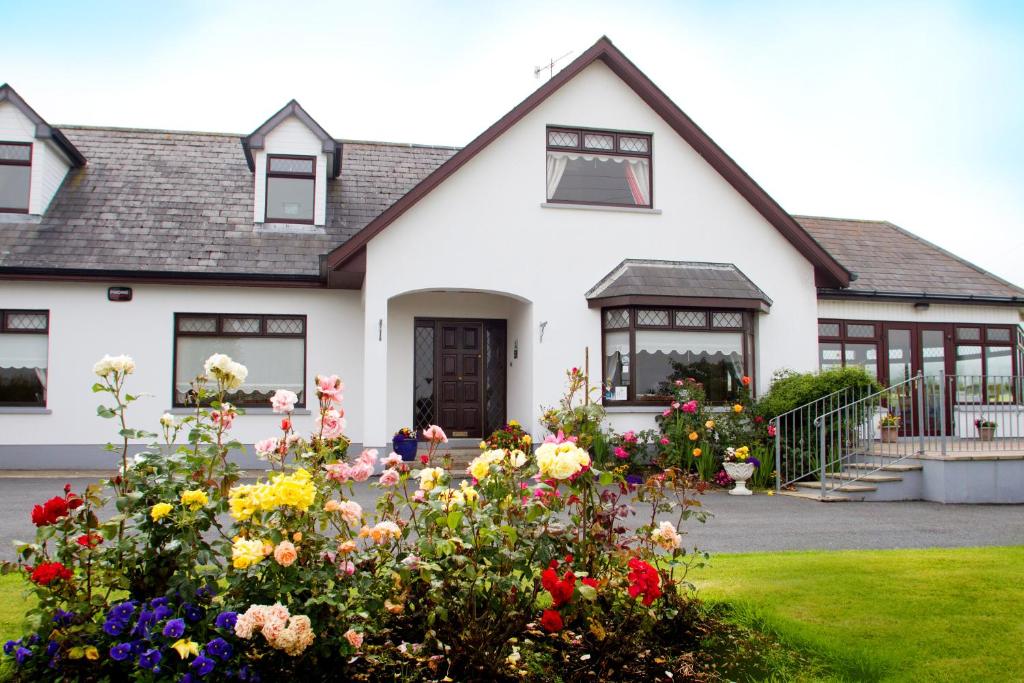 a house with flowers in the front yard at Mourneview B & B in Carlingford