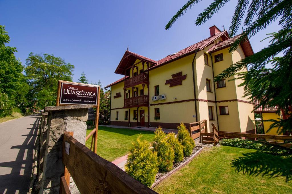 a building with a sign in front of it at Willa Uliaszówka in Szczawnica