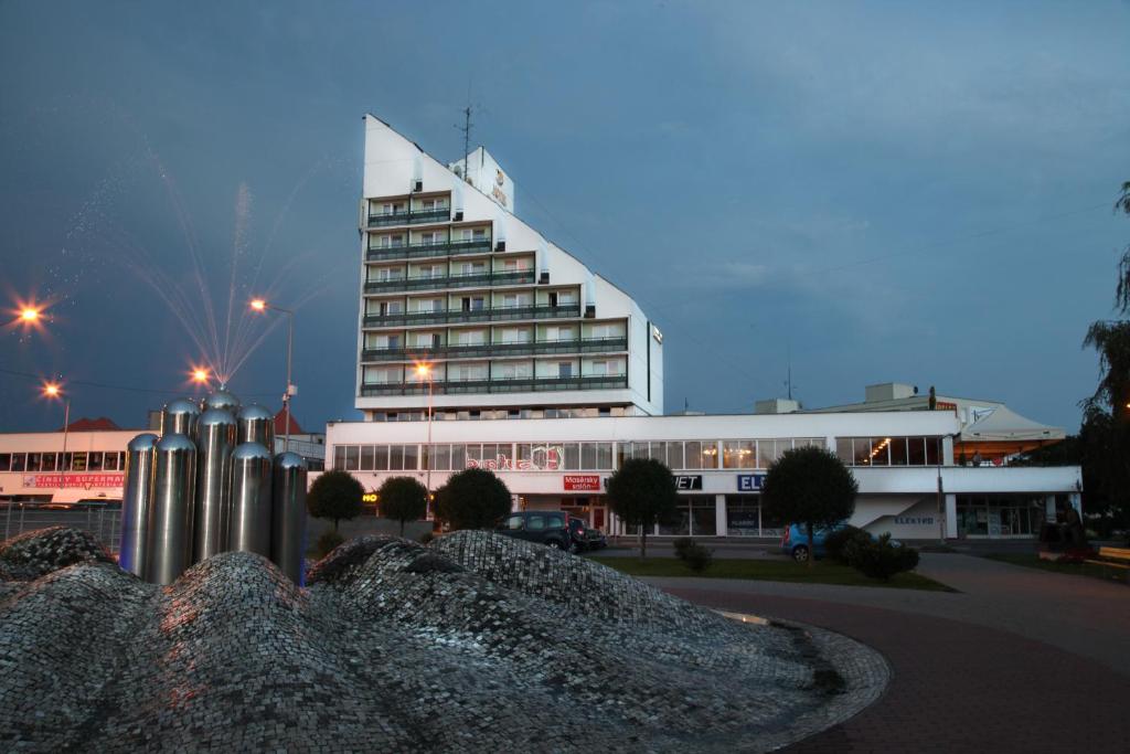 - un grand bâtiment blanc avec un escalier dans l'établissement Hotel Zlatý Býk, à Rimavská Sobota