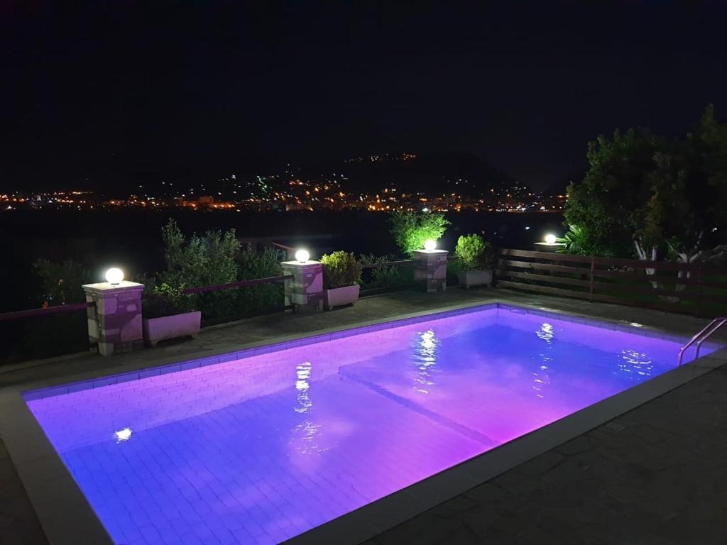 a swimming pool at night with purple lights at Vila Palma in Berat