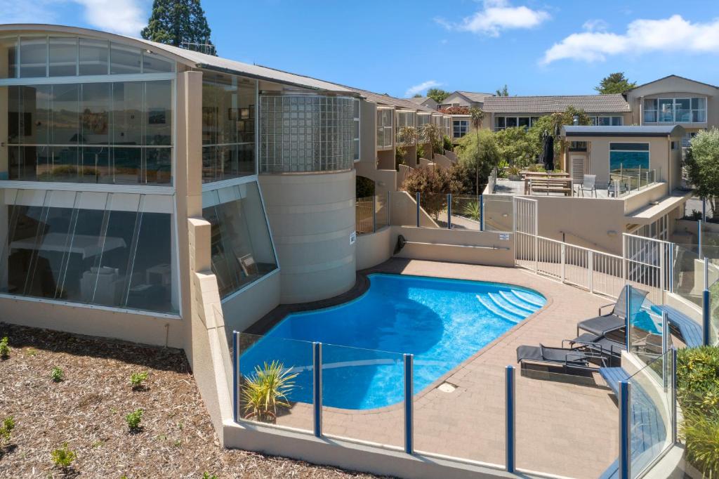 a house with a swimming pool in front of it at The Village Resort in Taupo