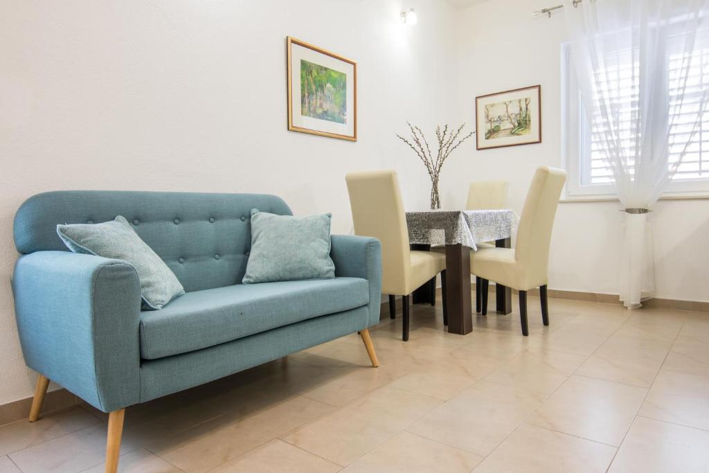 a living room with a blue couch and a table at Apartments Fanito in Makarska