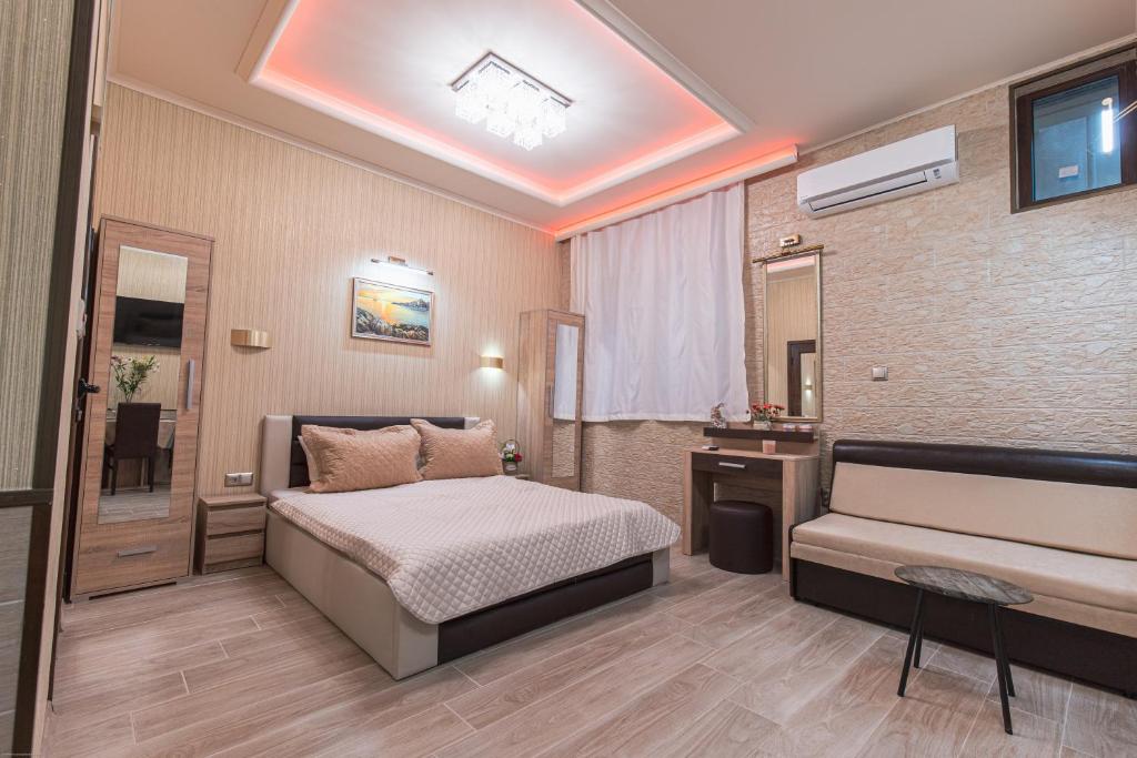 a bedroom with a bed and a sink and a mirror at Deluxe Studios City Center in Burgas City
