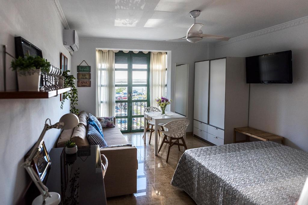a bedroom with a bed and a living room at Suite Mirando al Guadiana in Ayamonte