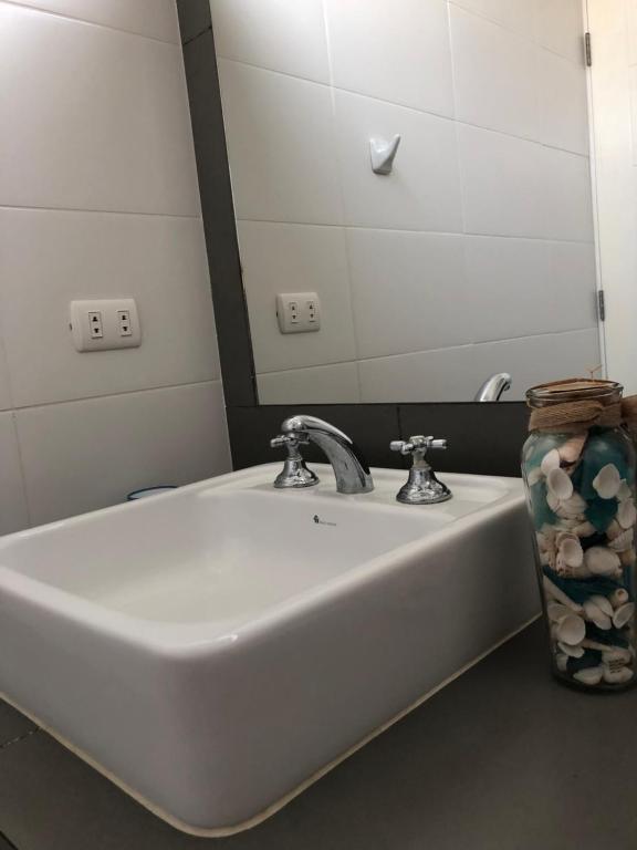 lavabo blanco en el baño con espejo en Apartamento Frente a Islas Ballestas, en Paracas