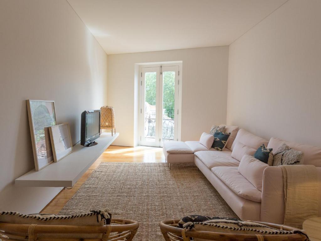 uma sala de estar com um sofá e uma televisão em Casa Castanha em Porto