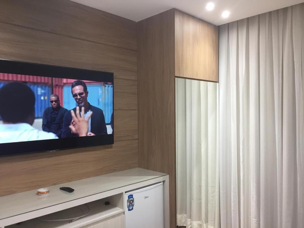 um quarto com uma televisão de ecrã plano na parede em Flat de luxo em Lagoa Santa/MG em Lagoa Santa