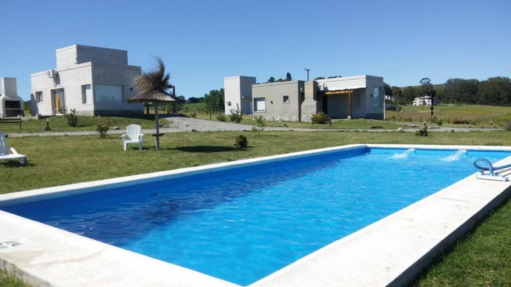 a large blue swimming pool in front of a building at Cabañas Calihue in Tandil
