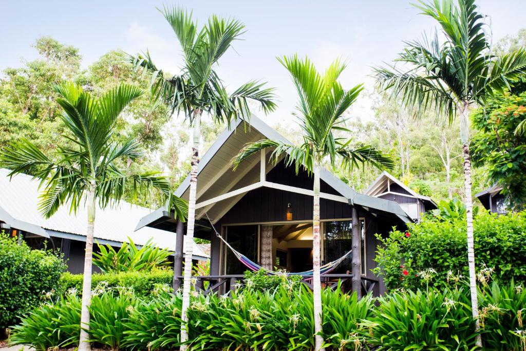 une maison avec des palmiers devant elle dans l'établissement Palm Bungalows, à Île Hamilton