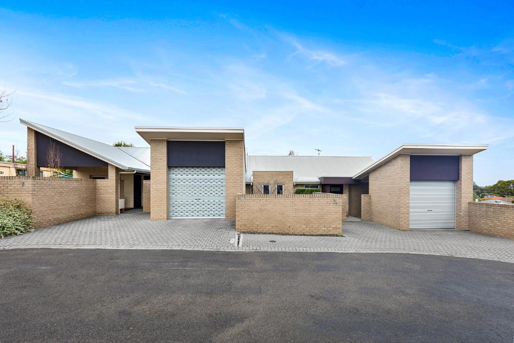 a house with two garage doors on a driveway at Frewville 7 Apartment in Mount Gambier
