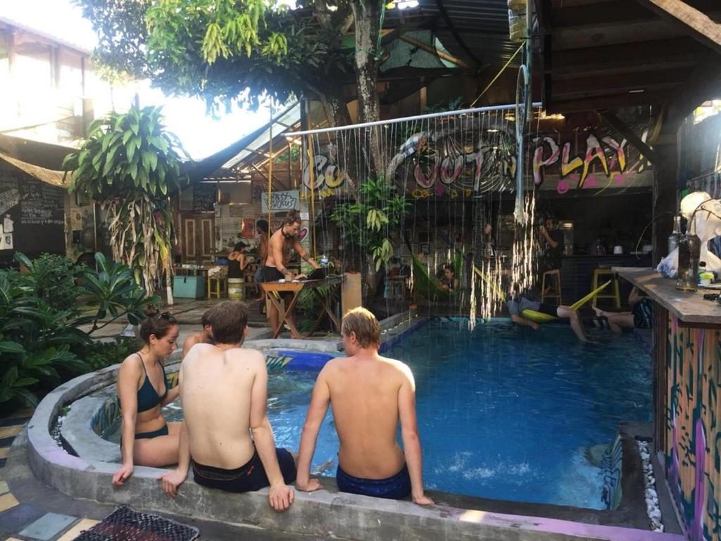 een groep van drie personen zittend in een zwembad bij Yez Yez Yez All Good Hostel in Yogyakarta