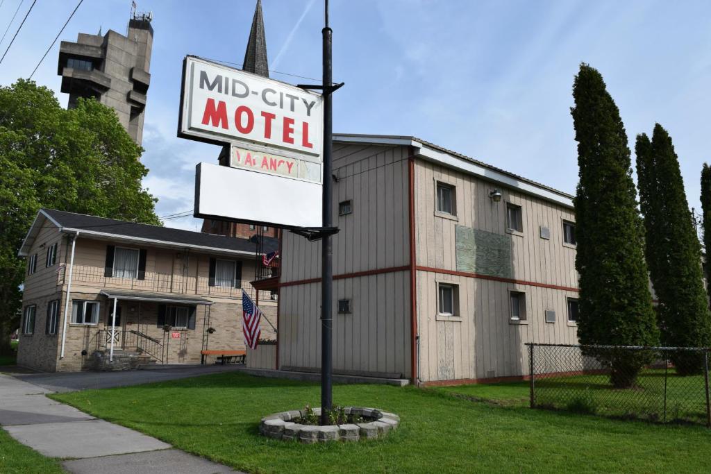 un cartello di un motel di fronte a un edificio di Mid-City Motel a Sault Ste. Marie