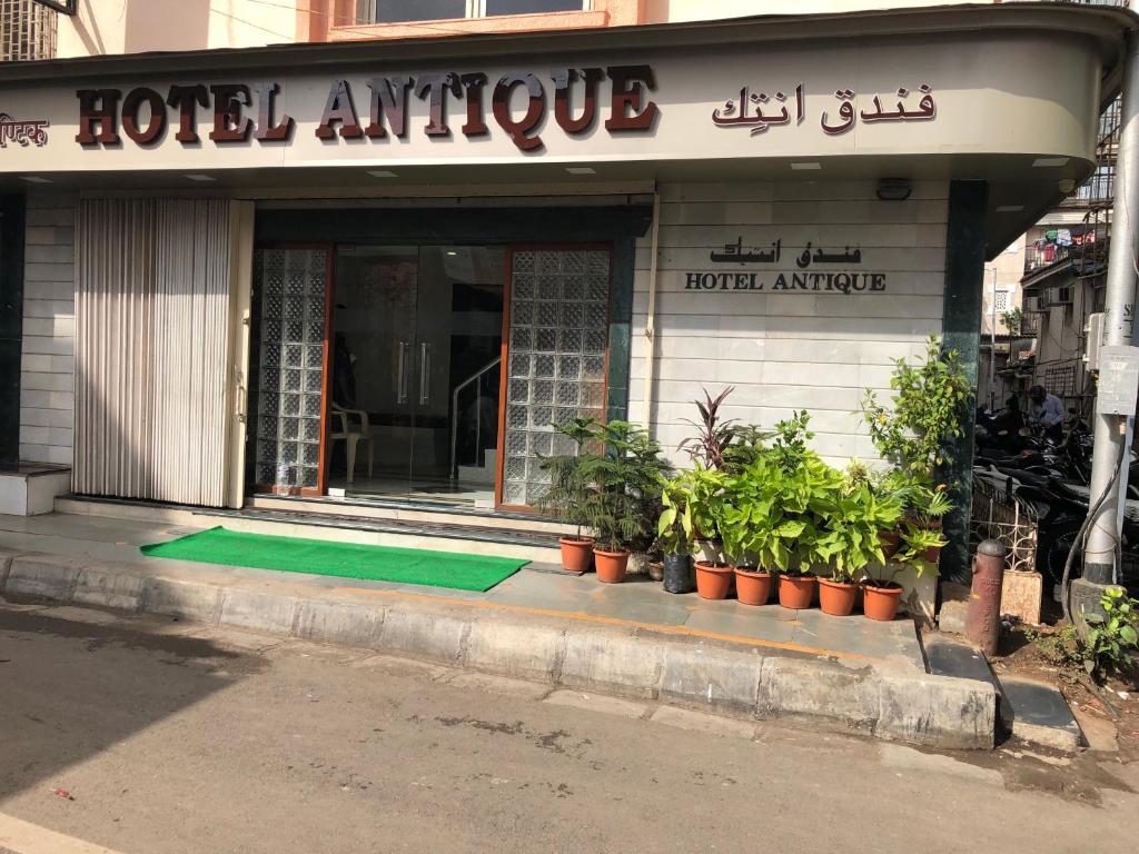 a hotel entrance with a green mat in front of it at Hotel Antique - Colaba in Mumbai