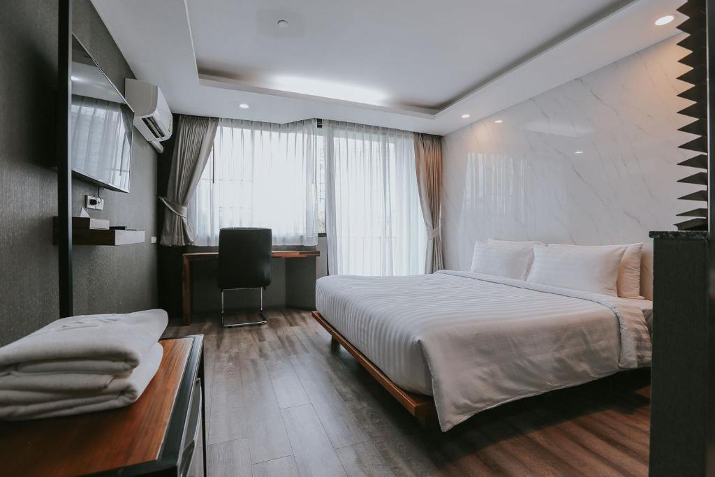 Pokój hotelowy z dużym łóżkiem i biurkiem w obiekcie Bangkok City Link Hotel w mieście Bangkok