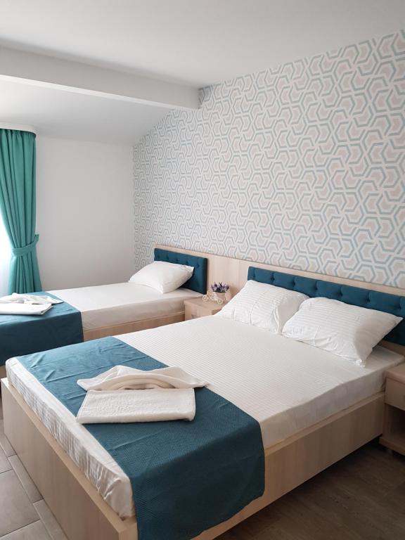 a bedroom with two beds with blue and white at Vila Yly in Eforie Nord