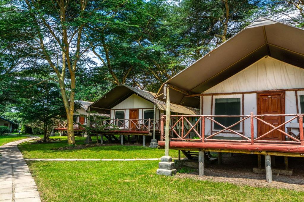 奈瓦沙的住宿－Lake Naivasha Crescent Camp，前面有红色长凳的小房子