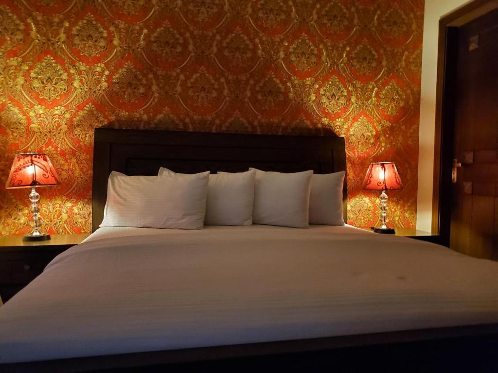 um quarto com uma cama grande e 2 candeeiros em Mulberry Guest House F-10 em Islamabad