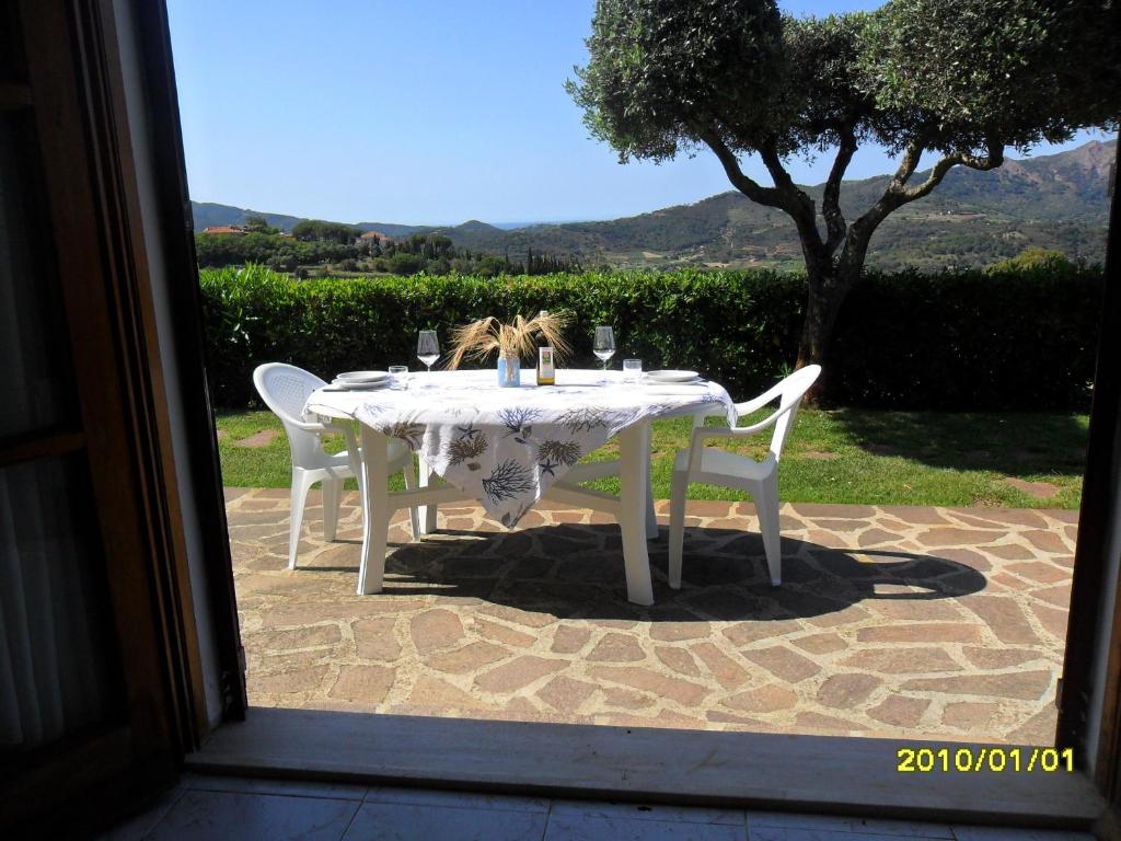 een tafel met een wit tafelkleed en twee stoelen bij I SALICI in Capoliveri