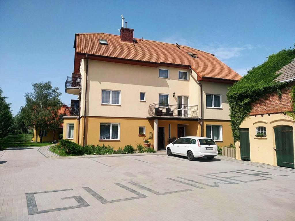 a white car parked in front of a building at Guliwer in Niechorze