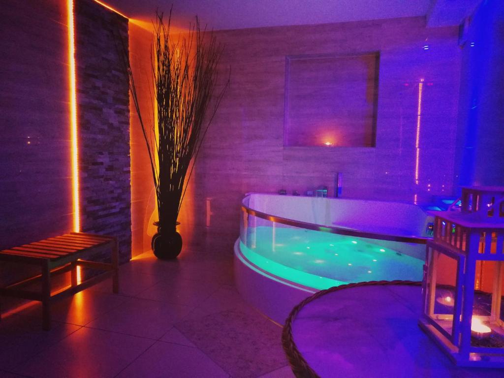 baño con bañera con luces moradas y verdes en Willa Panorama Medical Spa, en Ustroń