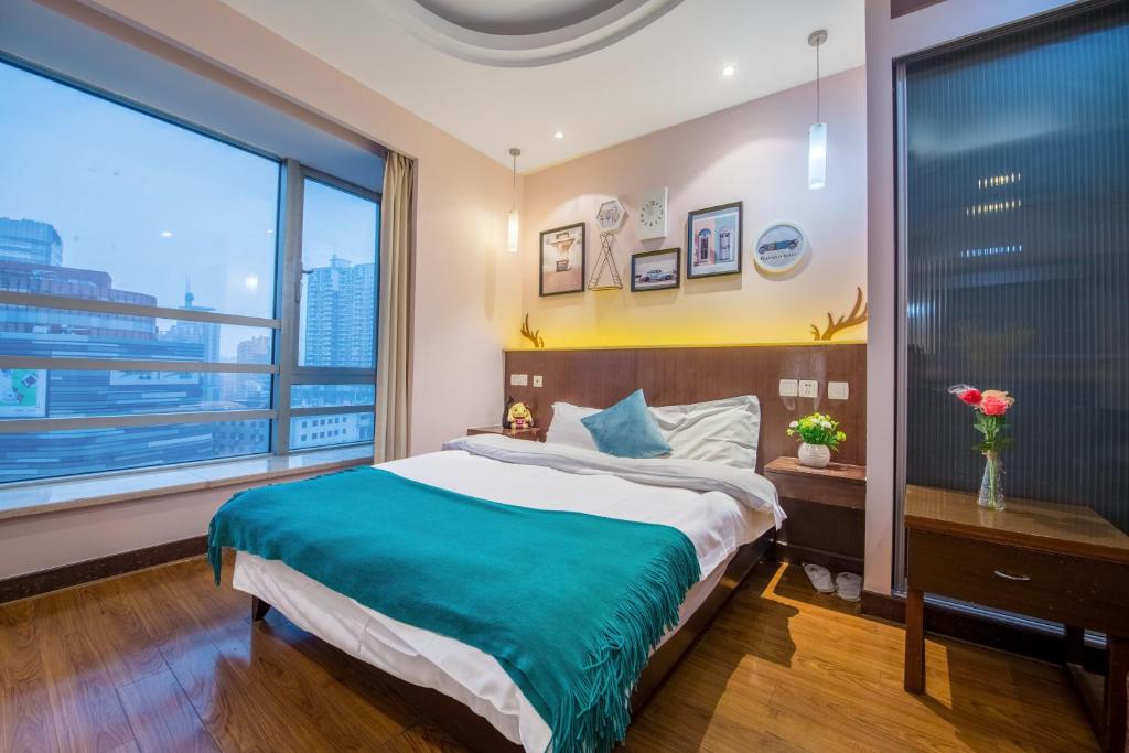 a bedroom with a large bed and a large window at Shanghai Jiarong Hotel Apartment in Shanghai
