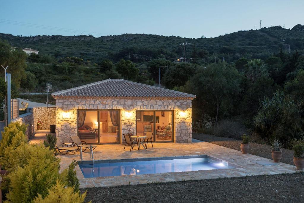 una pequeña casa con una piscina frente a ella en David's Villas - Private Pool & Scenic Surroundings, en Vasilikos
