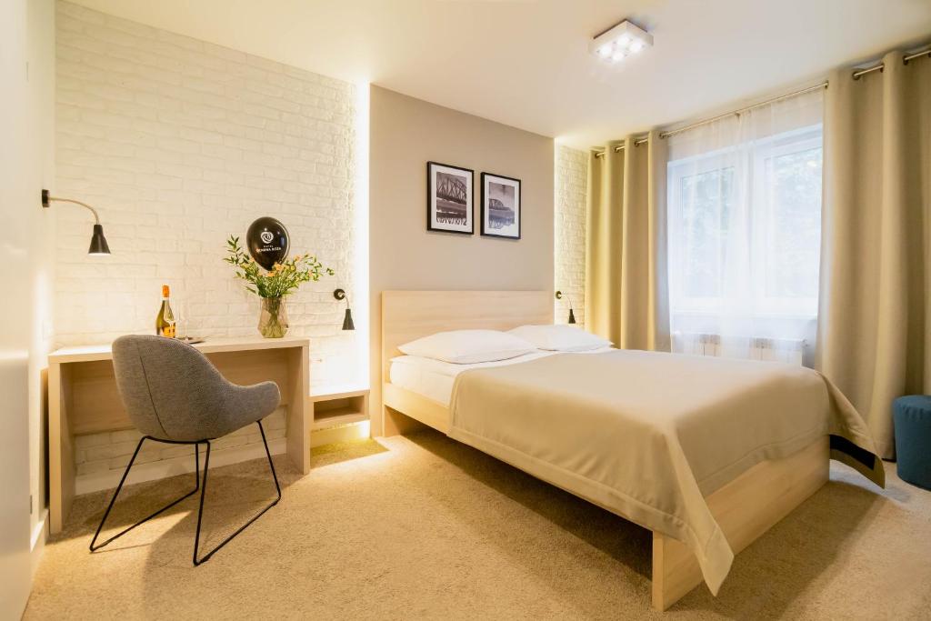 um quarto com uma cama, uma secretária e uma cadeira em Hotel Czarna Róża em Toruń