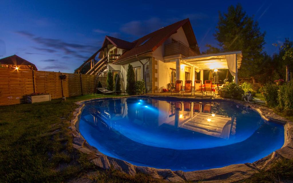 a swimming pool in front of a house at night at Apartamenty Wiakówka in Kazimierz Dolny