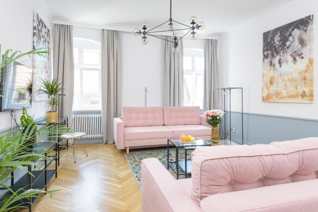salon z różowymi meblami i roślinami w obiekcie Apartament Kopernik w Toruniu